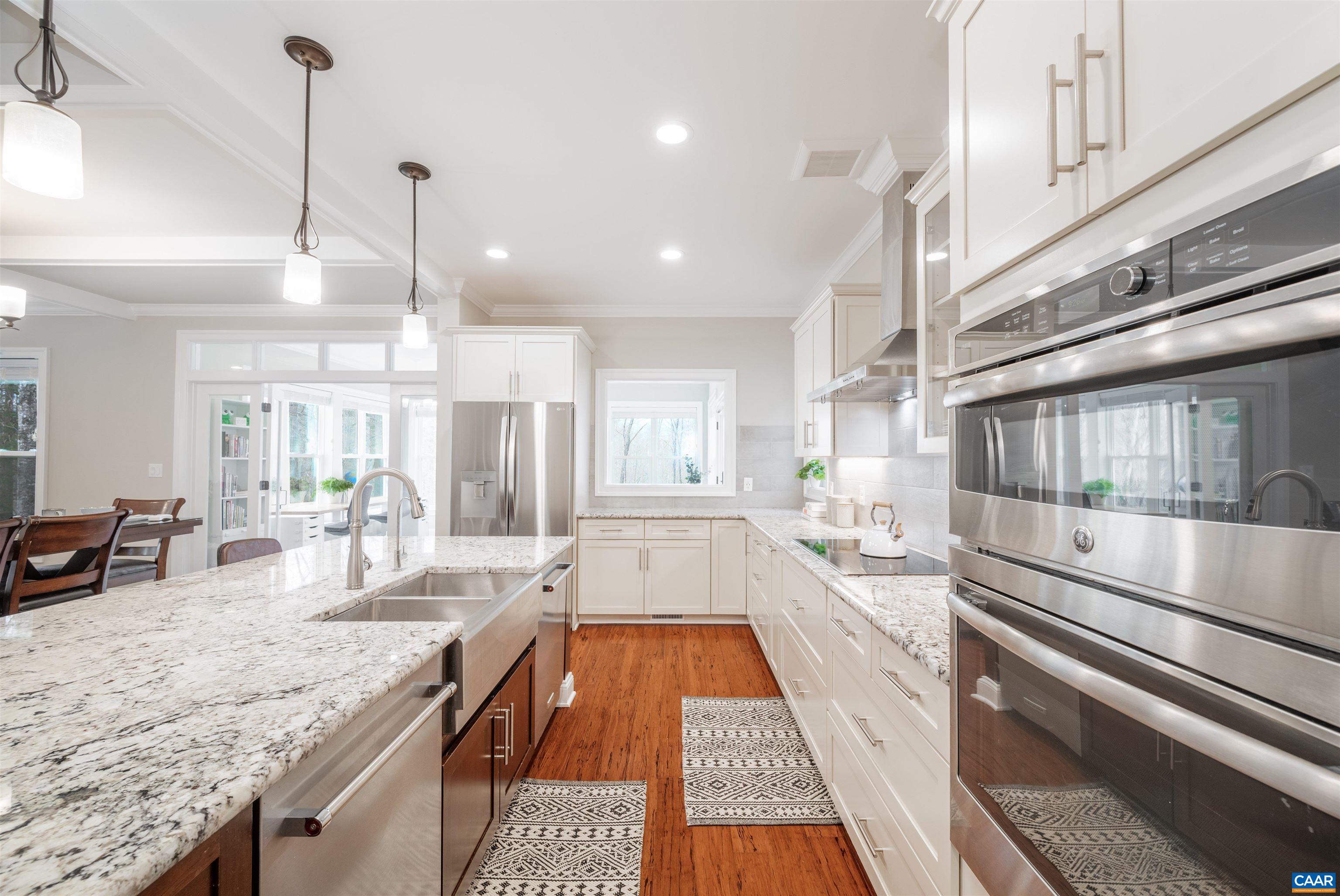 303 Turkey Ridge Road Charlottesville, VA 22903 - Photo 15 of 49 a large kitchen with kitchen island a stove a sink dishwasher and wooden cabinets