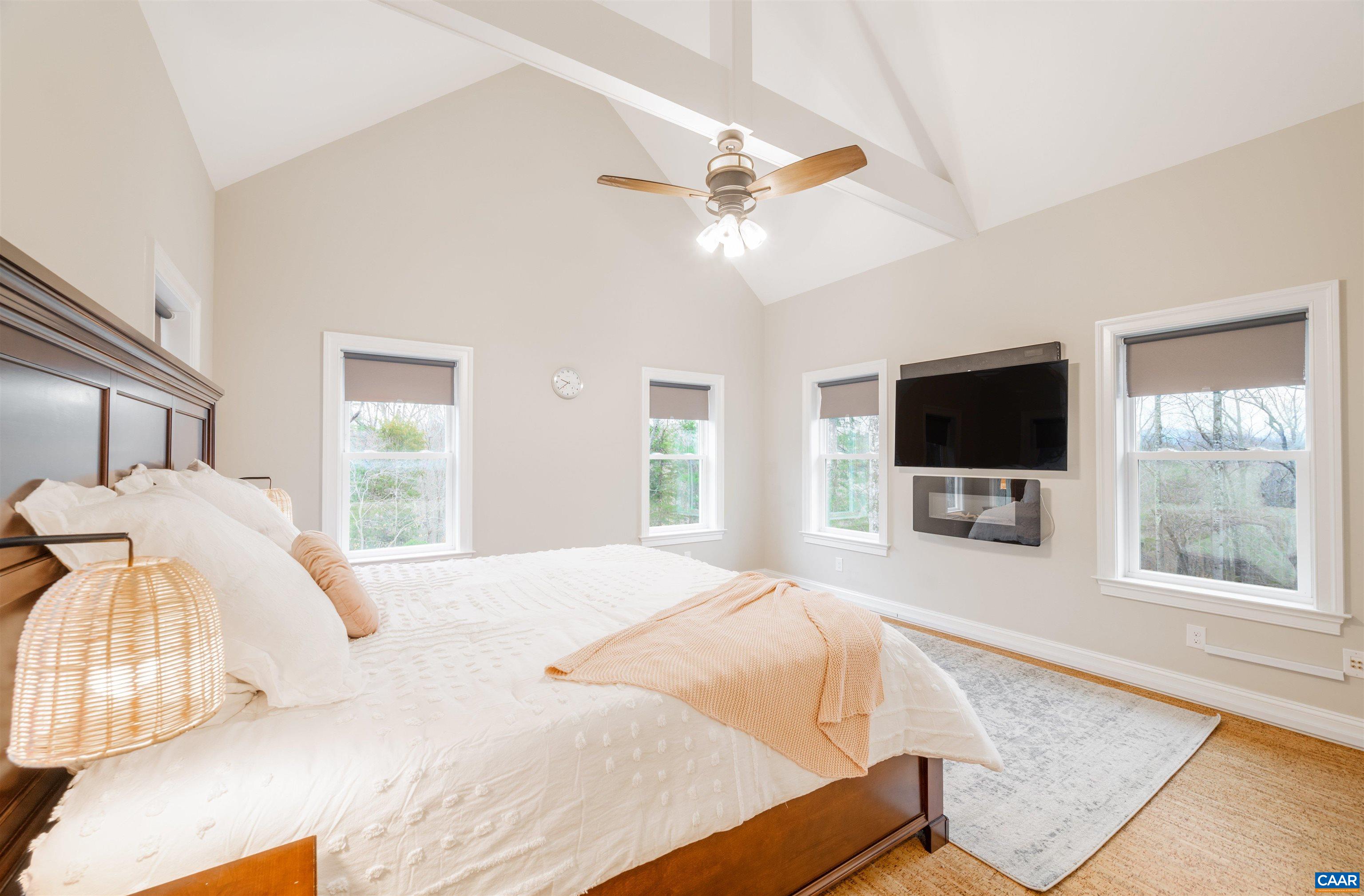 303 Turkey Ridge Road Charlottesville, VA 22903 - Photo 24 of 49 a bedroom with a bed window and a flat screen tv