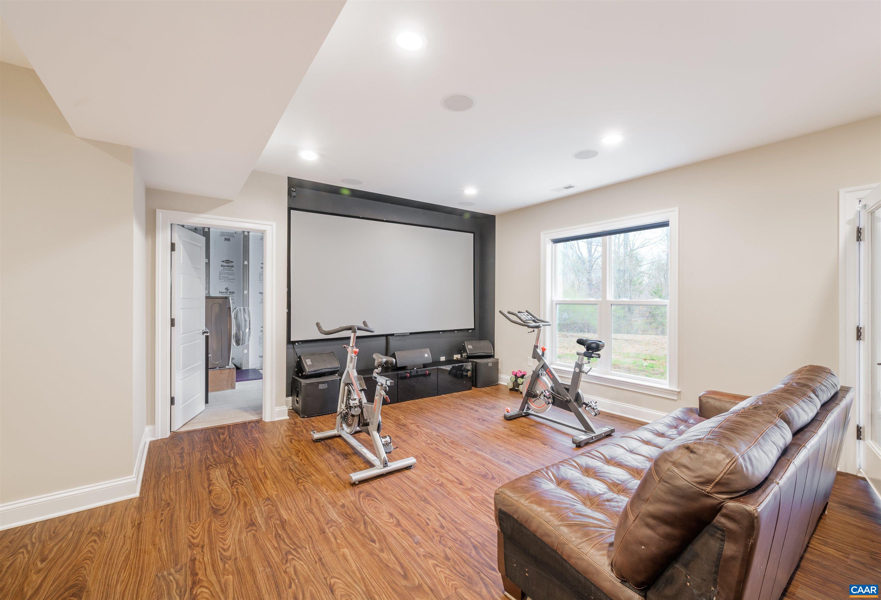 303 Turkey Ridge Road Charlottesville, VA 22903 - Photo 36 of 49 a living room with furniture a wooden floor and a large window