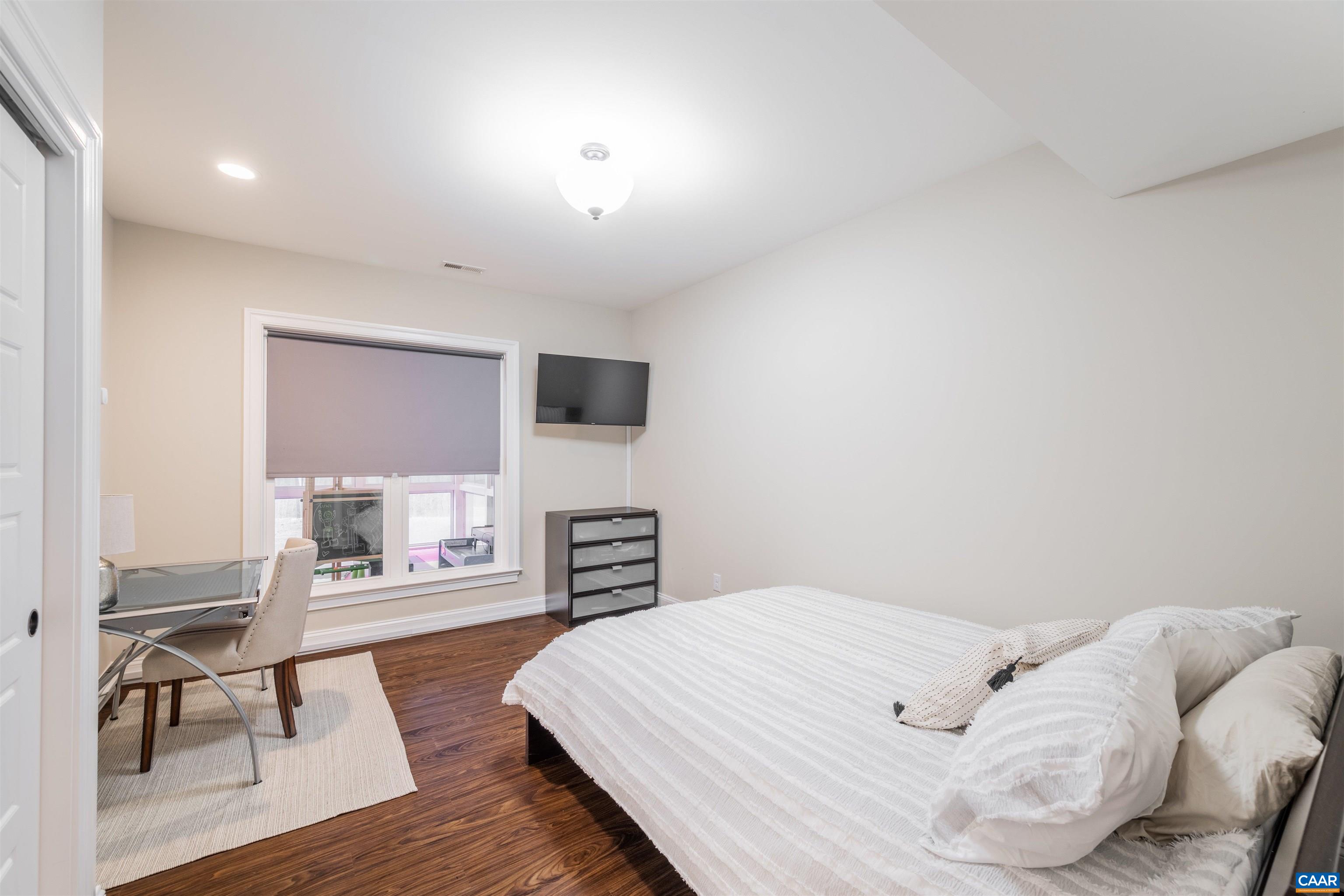 303 Turkey Ridge Road Charlottesville, VA 22903 - Photo 37 of 49 a bedroom with a bed and wooden floor