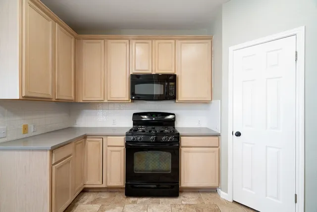 a kitchen with granite countertop white cabinets and a sink