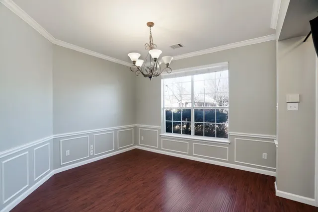 a view of wooden floor chandelier and window in a room