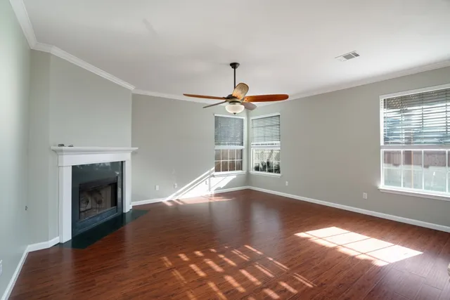 a view of empty room with wooden floor fireplace and windows
