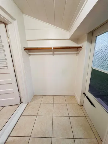 a view of an empty room with wooden floor and a fireplace