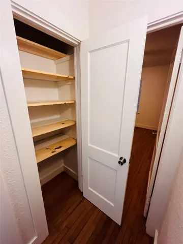a view of walk in closet with wooden floor