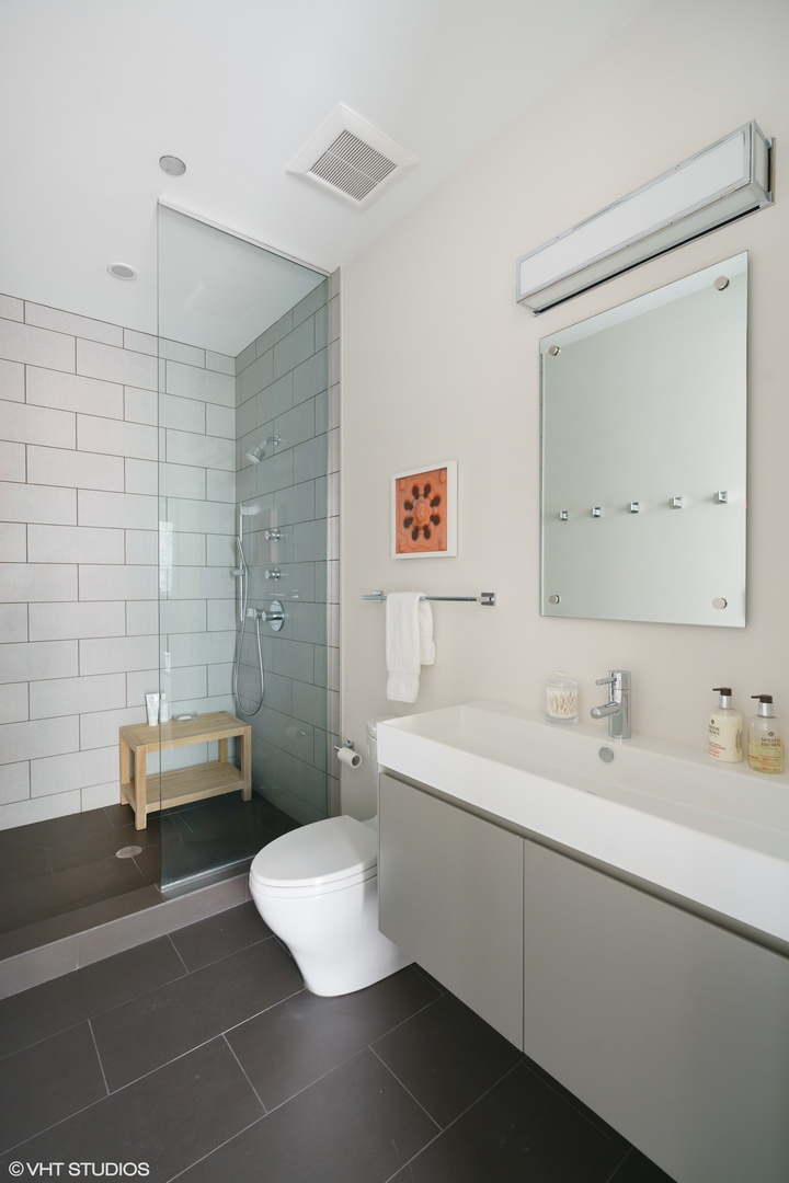 747 North Clark Street, Unit 201 Chicago, IL 60654 - Photo 23 of 30 a bathroom with a sink a toilet and a mirror