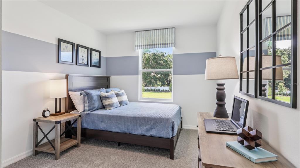 6590 Southwest 82nd Loop Ocala, FL 34476 - Photo 16 of 22 a bedroom with a bed a lamp and a window