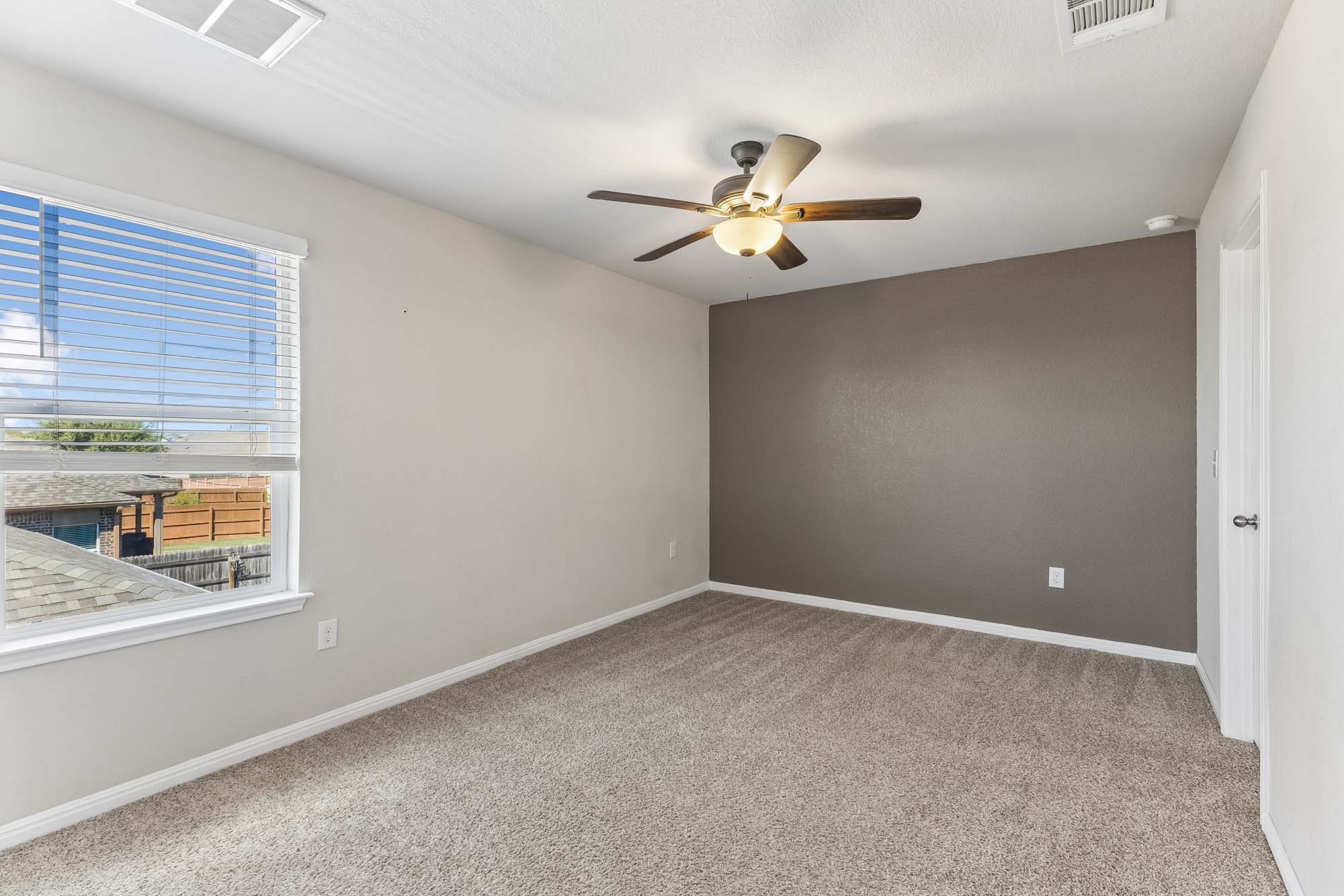 124 Moravia Road Georgetown, TX 78626 - Photo 19 of 38 Plush carpeting and a large window bring warmth to this versatile secondary bedroom.