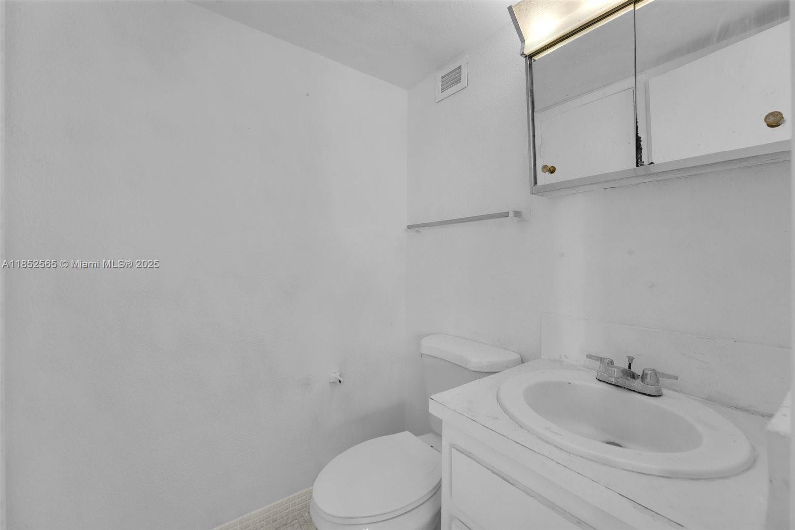 1750 James Avenue, Unit 7L Miami Beach, FL 33139 - Photo 9 of 27 a white toilet sitting next to a bathroom sink