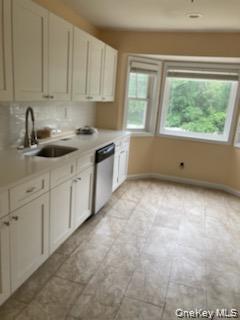 1455 East Forks Road Bay Shore, NY 11706 - Photo 5 of 7 a kitchen with granite countertop white cabinets and window