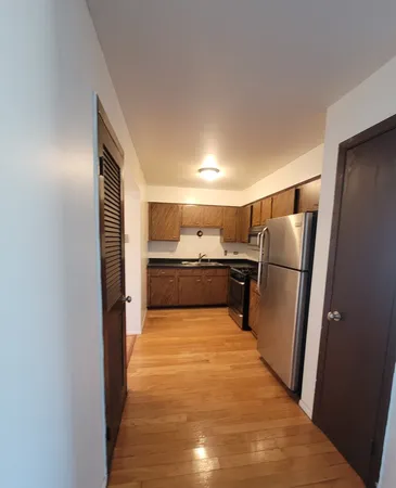 a view of a refrigerator in kitchen and wooden floor