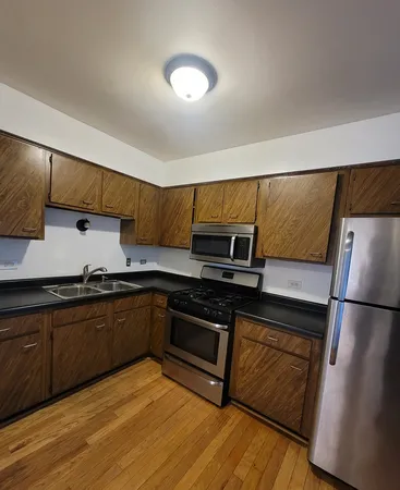 a kitchen with stainless steel appliances granite countertop a stove a sink and a refrigerator