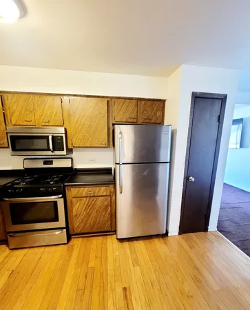 a view of kitchen with stainless steel appliances wooden floor