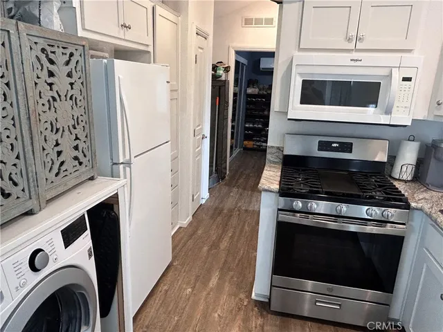 a bathroom with a granite countertop toilet a sink and a mirror