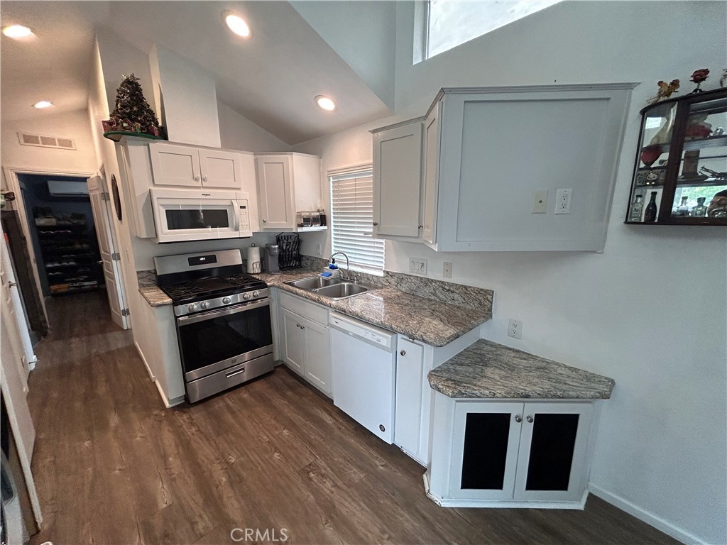 1409 Redlands Boulevard, Unit 27 Redlands, CA 92373 - Photo 12 of 15 a kitchen with stainless steel appliances granite countertop a stove a sink and a microwave