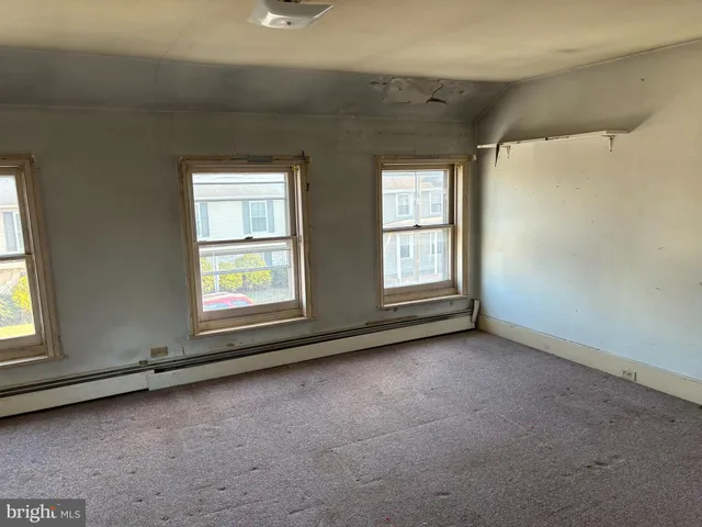 an empty room with windows and closet