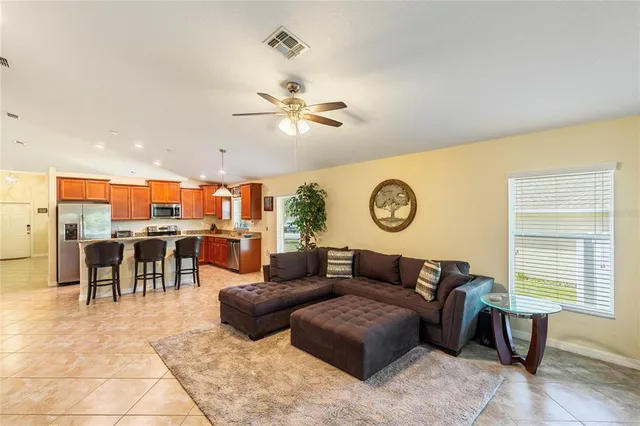 a living room with furniture a table and kitchen view