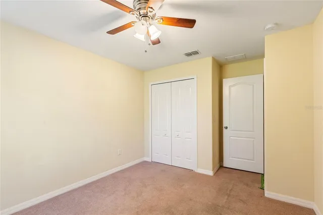 an empty room with a chandelier fan and a chandelier fan