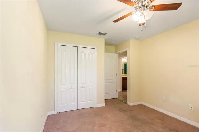 an empty room with a chandelier fan and a chandelier fan