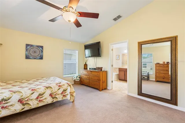 a bedroom with a large bed and a chandelier