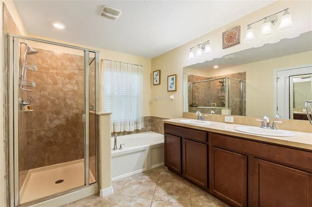 a bathroom with a double vanity sink mirror and shower