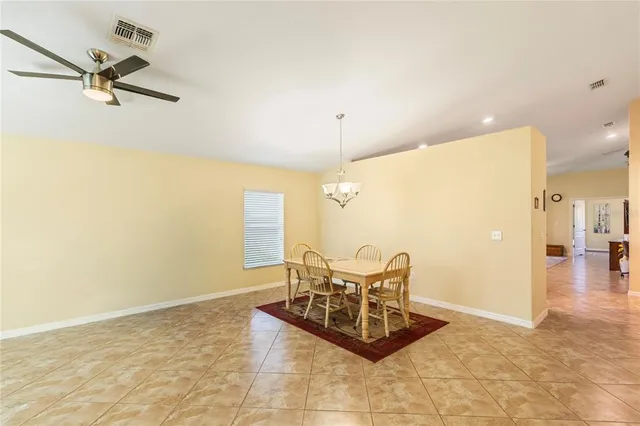 a living room with couch chairs and a ceiling fan