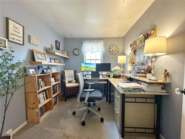 a view of a workspace with furniture and a window