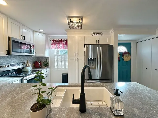 a kitchen with stainless steel appliances granite countertop a refrigerator and a sink