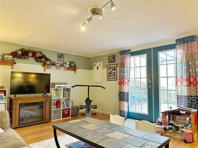 a living room with furniture a flat screen tv and a floor to ceiling window