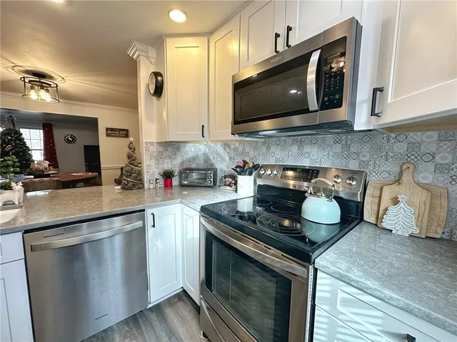 a kitchen with stainless steel appliances granite countertop a stove a microwave and cabinets