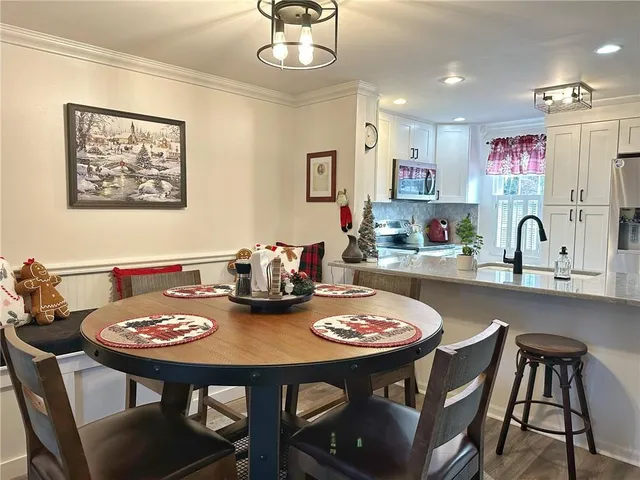 a kitchen with stainless steel appliances granite countertop a dining table and chairs