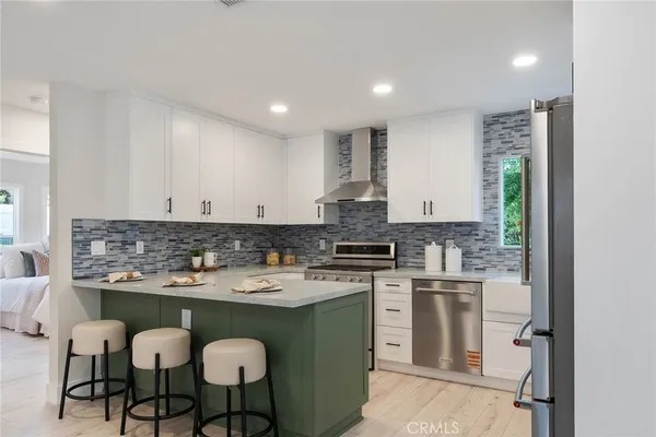 a kitchen with a stove a sink cabinets and a dining table