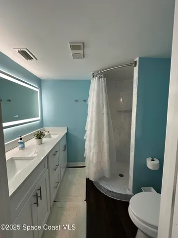 a bathroom with a granite countertop sink toilet and shower