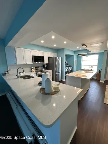 a kitchen with stainless steel appliances granite countertop a sink a stove and a refrigerator