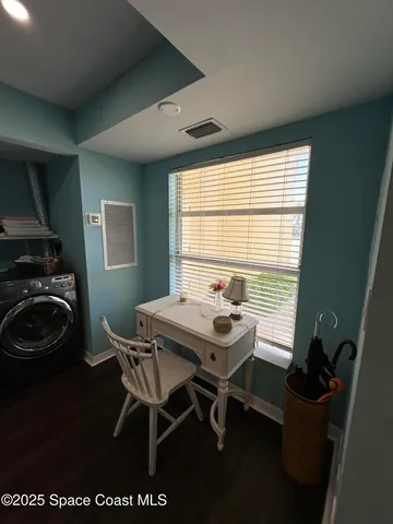 a view of a workspace with furniture and a window