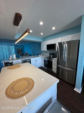 a kitchen with stainless steel appliances granite countertop a sink a stove and a refrigerator