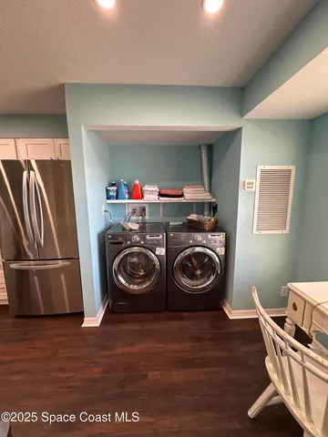 a utility room with wooden floor washer and dryer