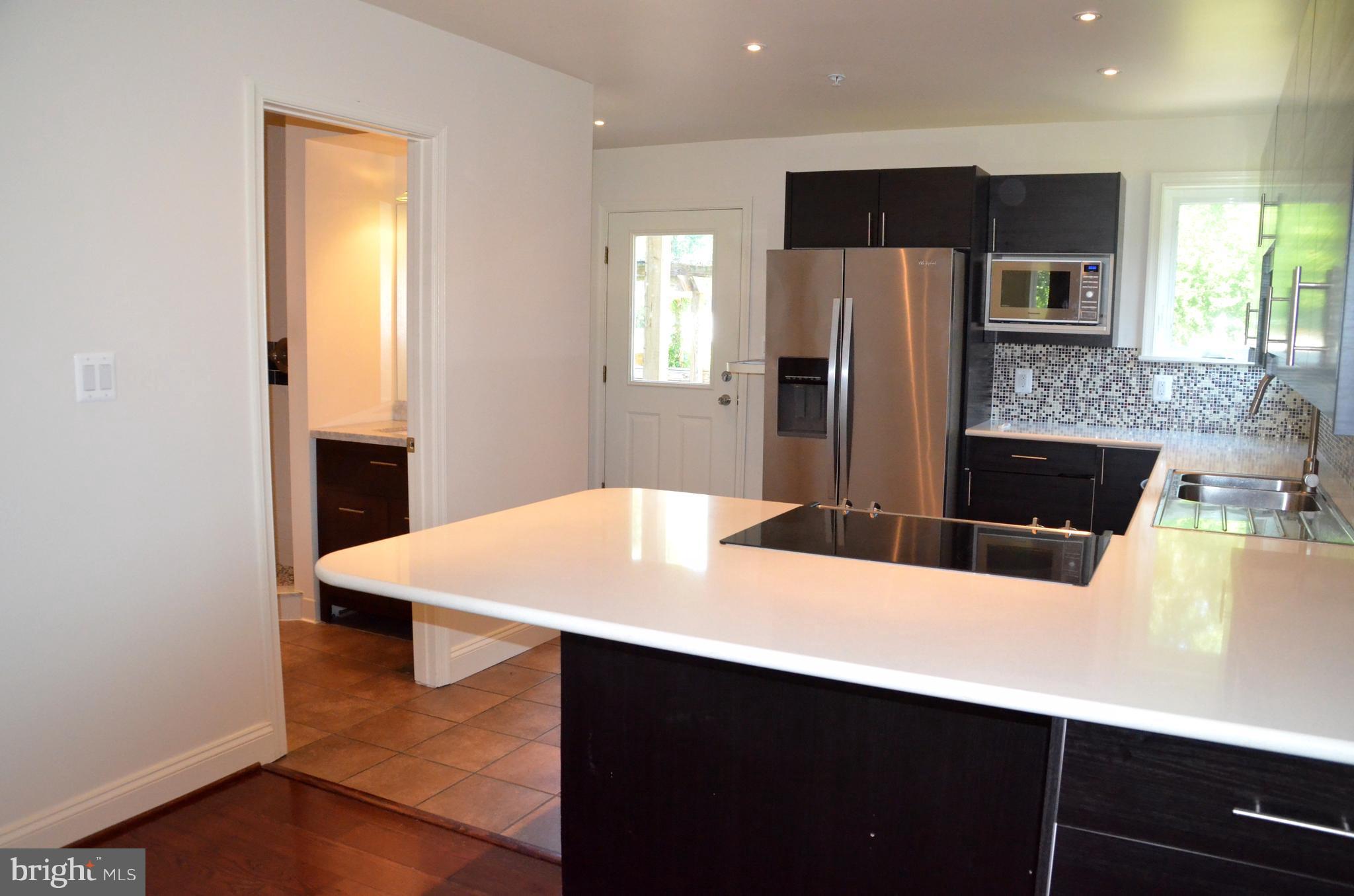 7370 Station Road Newcomb, MD 21653 - Photo 5 of 30 a kitchen with stainless steel appliances a kitchen island with cabinets and wooden floor
