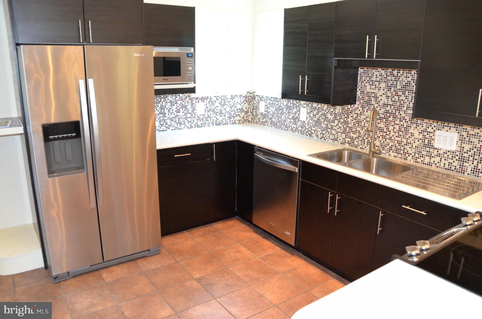 7370 Station Road Newcomb, MD 21653 - Photo 6 of 30 a kitchen with stainless steel appliances kitchen island granite countertop a refrigerator and a sink