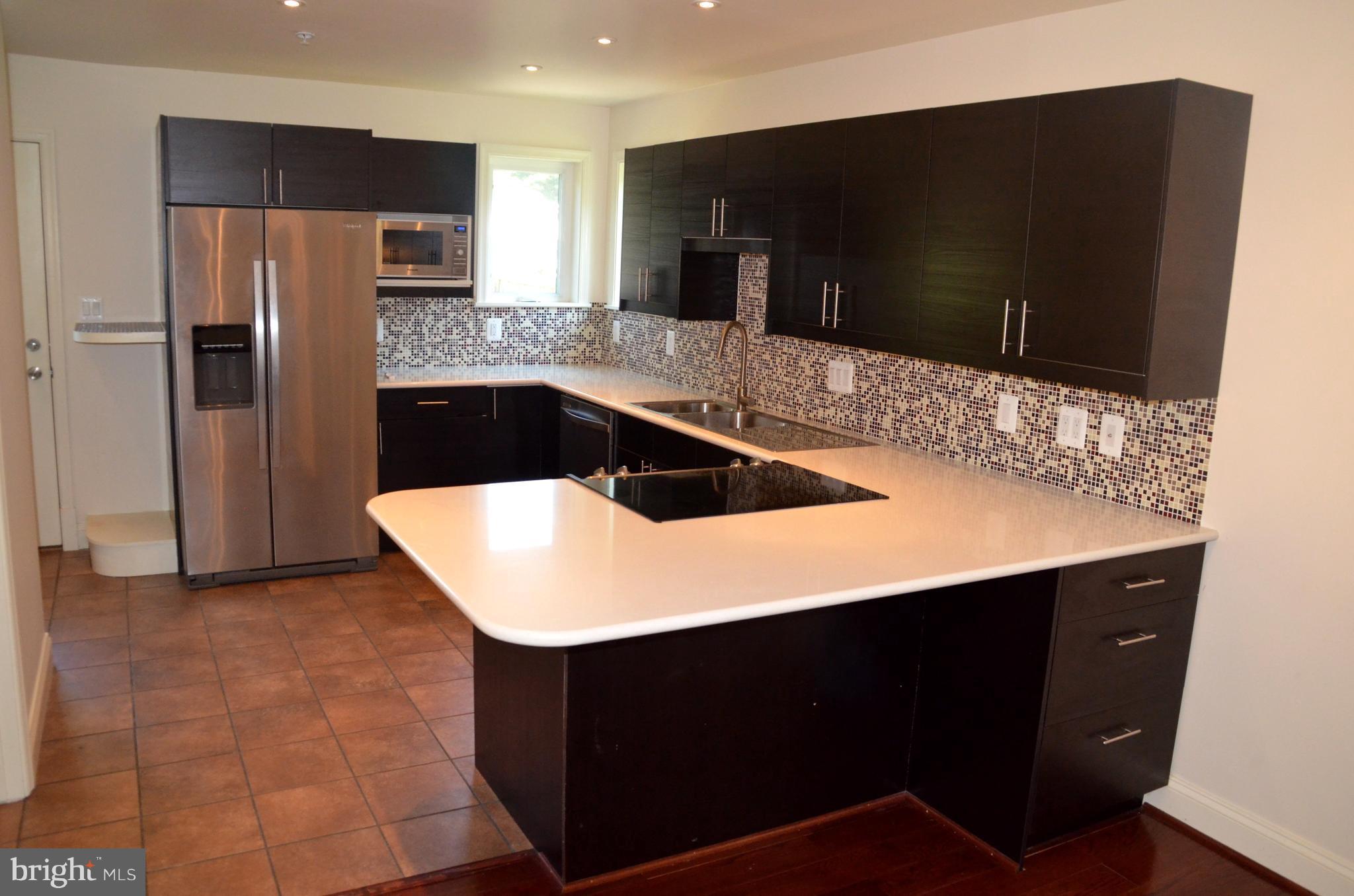 7370 Station Road Newcomb, MD 21653 - Photo 7 of 30 a kitchen with a sink a microwave a refrigerator and cabinets