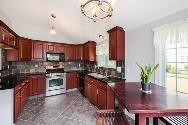 72 Ferry Road Salisbury, MA 01952 - Photo 8 of 30 a kitchen with stainless steel appliances granite countertop a stove a refrigerator a sink a microwave oven with a dining table and chairs