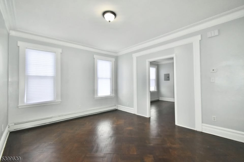 519 Clinton Place, Unit 2R Newark, NJ 07112 - Photo 1 of 14 an empty room with wooden floor and windows