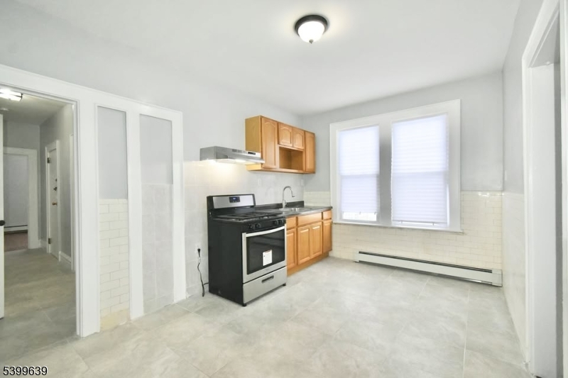 519 Clinton Place, Unit 2R Newark, NJ 07112 - Photo 12 of 14 a kitchen with granite countertop a stove a sink and a refrigerator