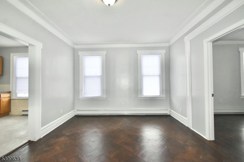 519 Clinton Place, Unit 2R Newark, NJ 07112 - Photo 2 of 14 an empty room with wooden floor and windows