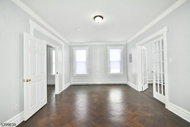 519 Clinton Place, Unit 2R Newark, NJ 07112 - Photo 3 of 14 an empty room with wooden floor and windows