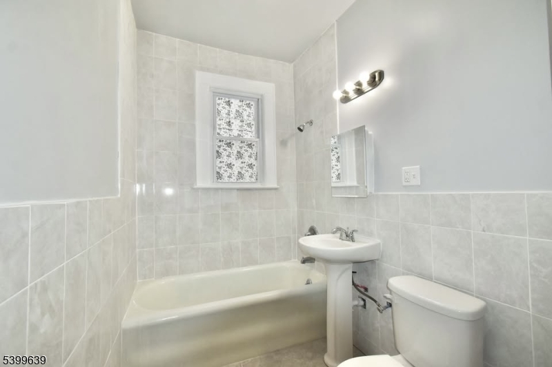 519 Clinton Place, Unit 2R Newark, NJ 07112 - Photo 9 of 14 a bathroom with a sink a toilet and shower