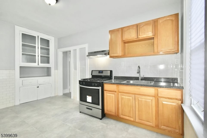 519 Clinton Place, Unit 2R Newark, NJ 07112 - Photo 10 of 14 a kitchen with granite countertop a stove a sink and a microwave
