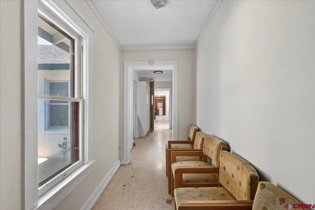 a view of a hallway with entryway and wooden floor