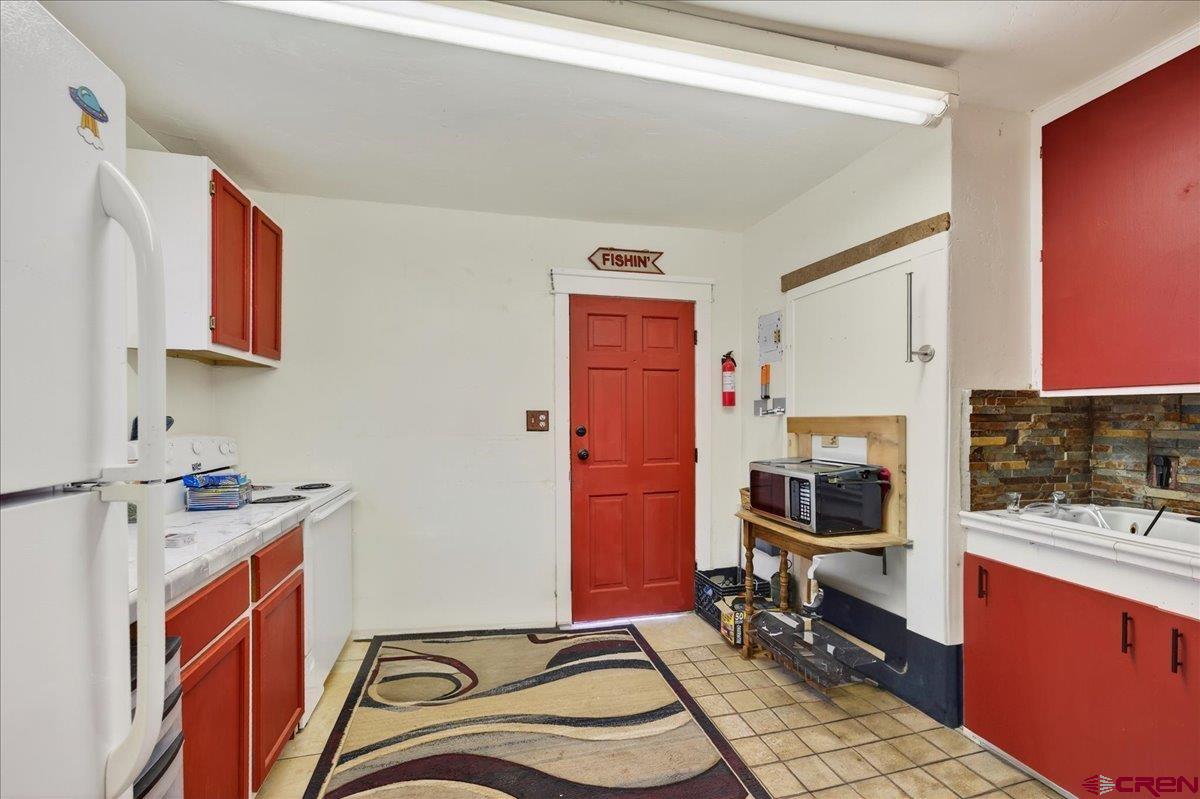 2091 Locust Road Montrose, CO 81401 - Photo 10 of 45 a room with furniture a flat screen tv and a stove