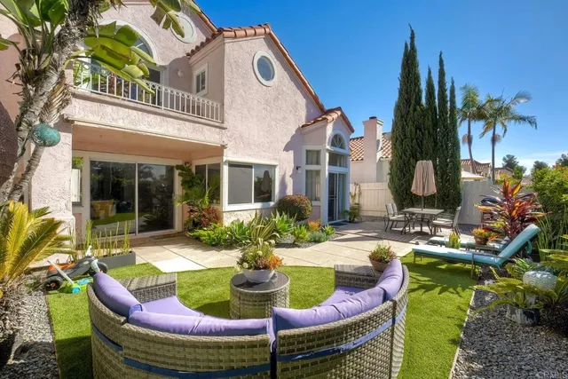 a view of a house with backyard and sitting area